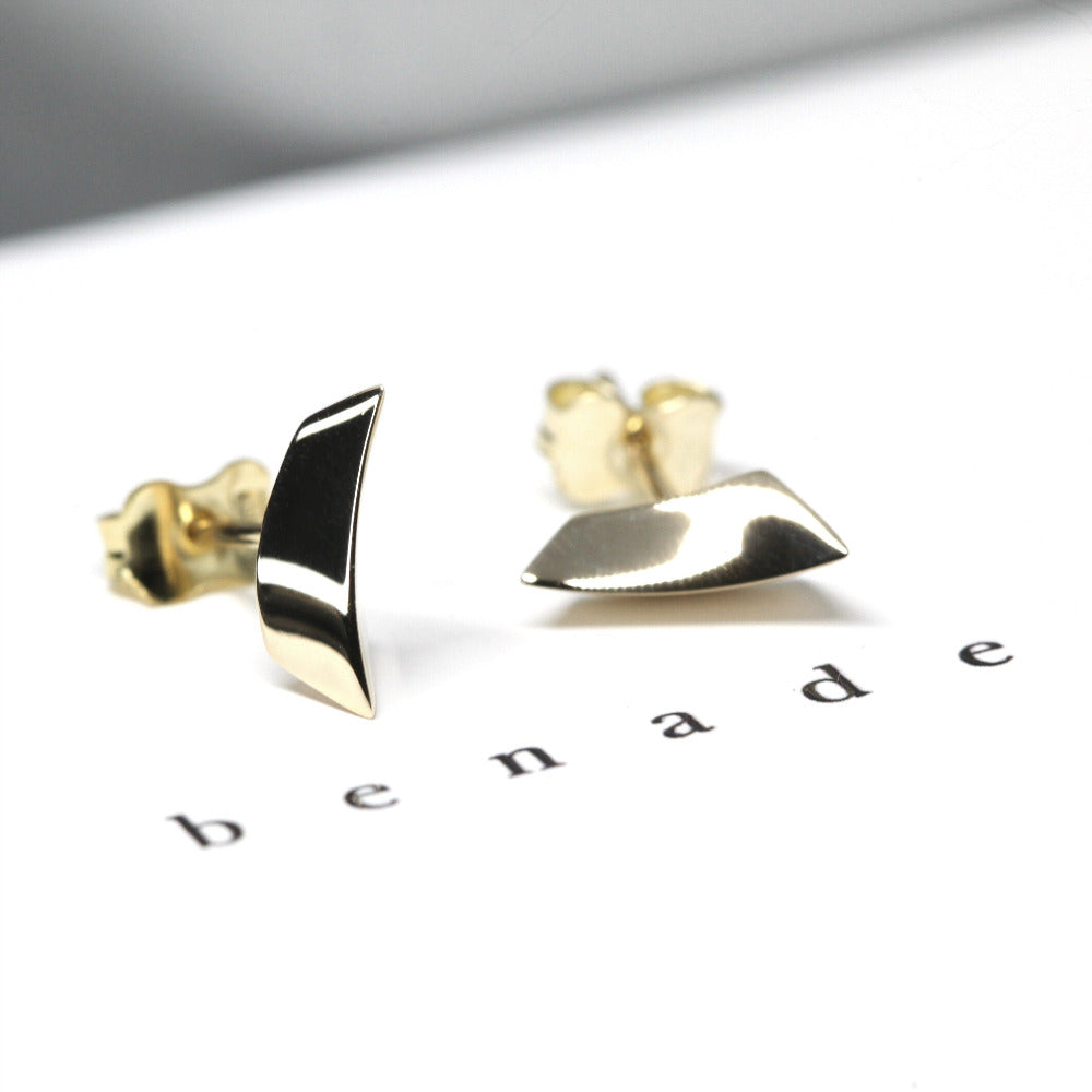 Minimalist earrings in yellow gold with a sharp, volumetric design for a striking play of light.