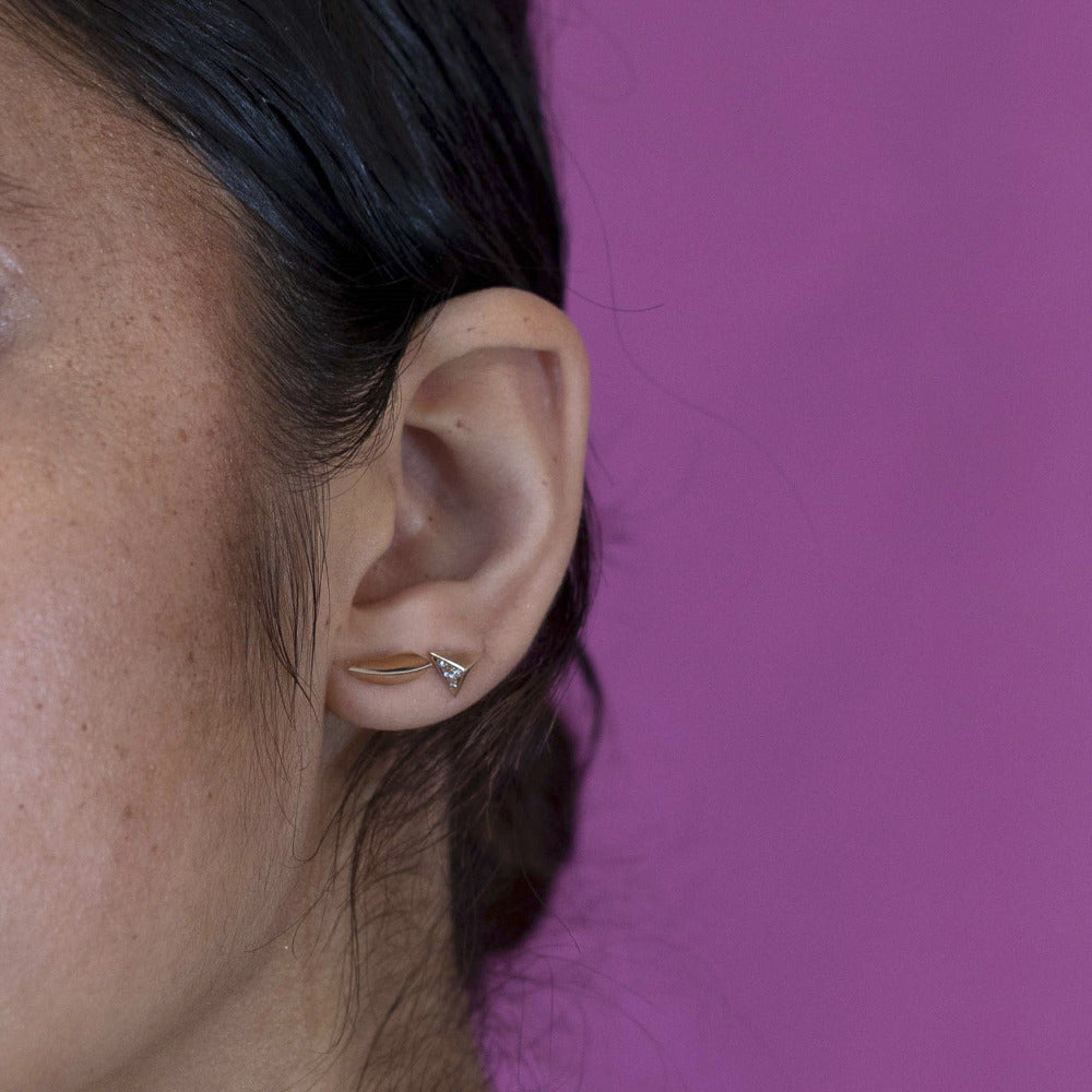 Girl wearing unisex yellow gold earrings with a unique bold design, perfect for versatile, everyday elegance. Minimalist modern jewelry design, from Canada.