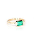 side view of bezel setting emerald gold custom made designer engagement ring in montreal with boutique ruby mardi best jewellery store in montreal on white background