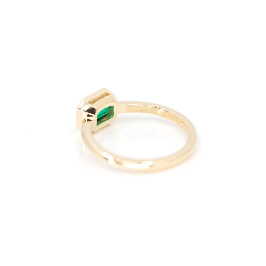 back view of yellow gold bezel setting green colored gemstone bridal designer engagement ring custom made in montreal white background