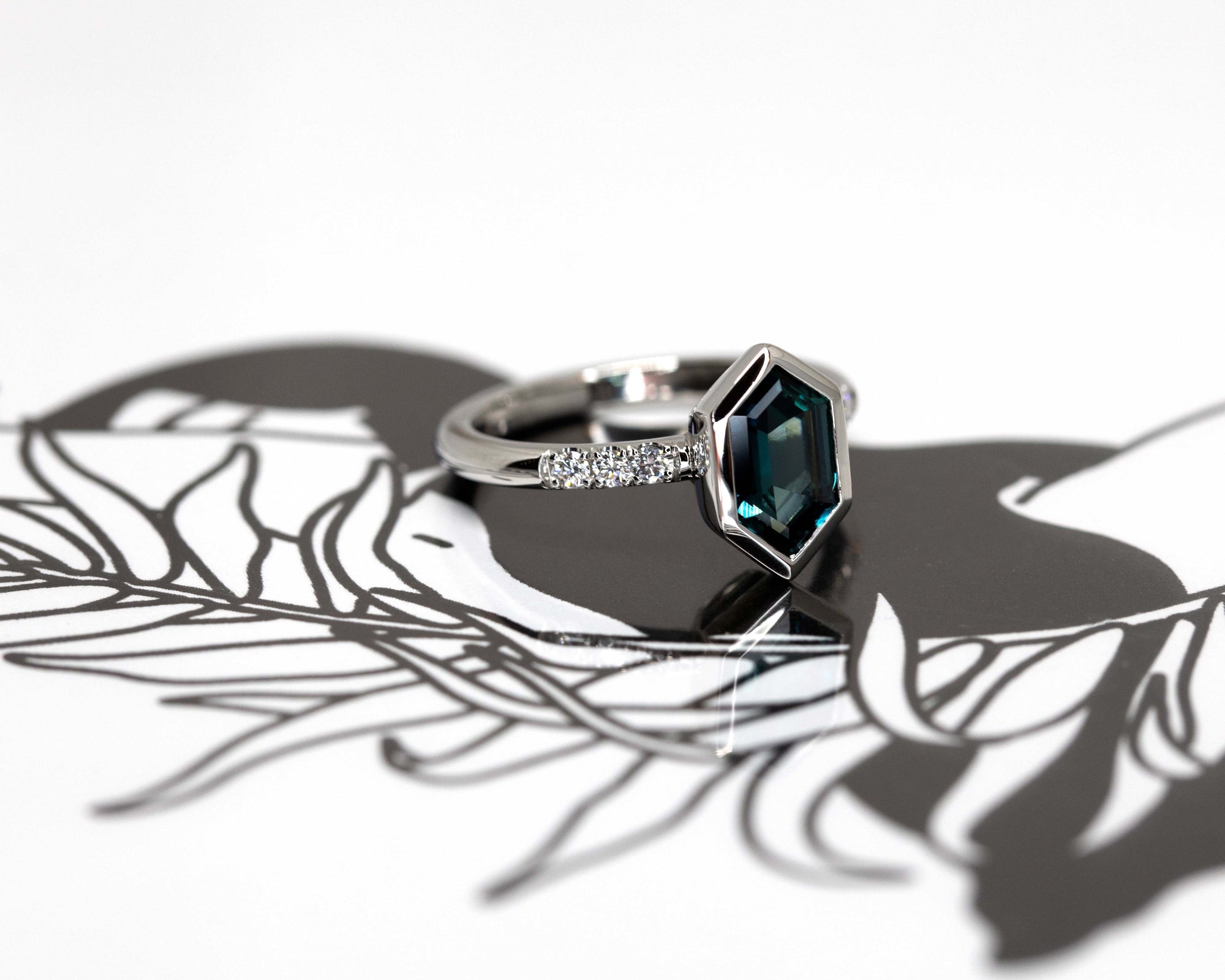 6. Hexagonal Sapphire Platinum Ring worn on hand – A stunning engagement ring with an electric blue sapphire, designed for those who seek bold and unique fine jewelry.