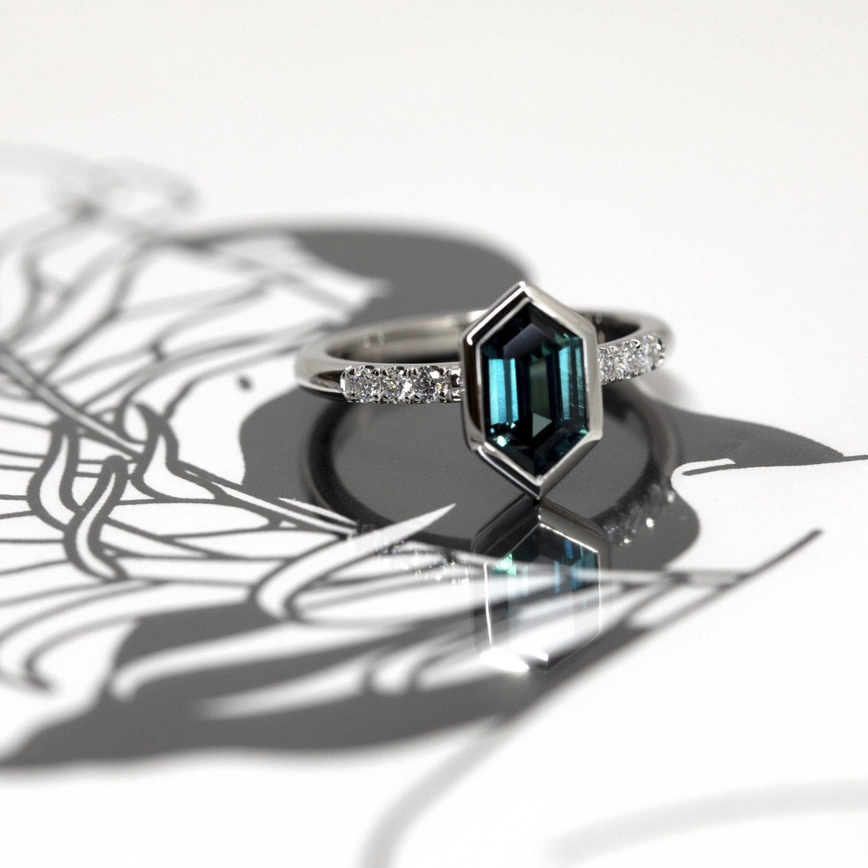 7. Sapphire and Diamond Platinum Ring in natural light – The deep blue sapphire sparkles brilliantly, set in an elegant platinum band with diamond accents.
