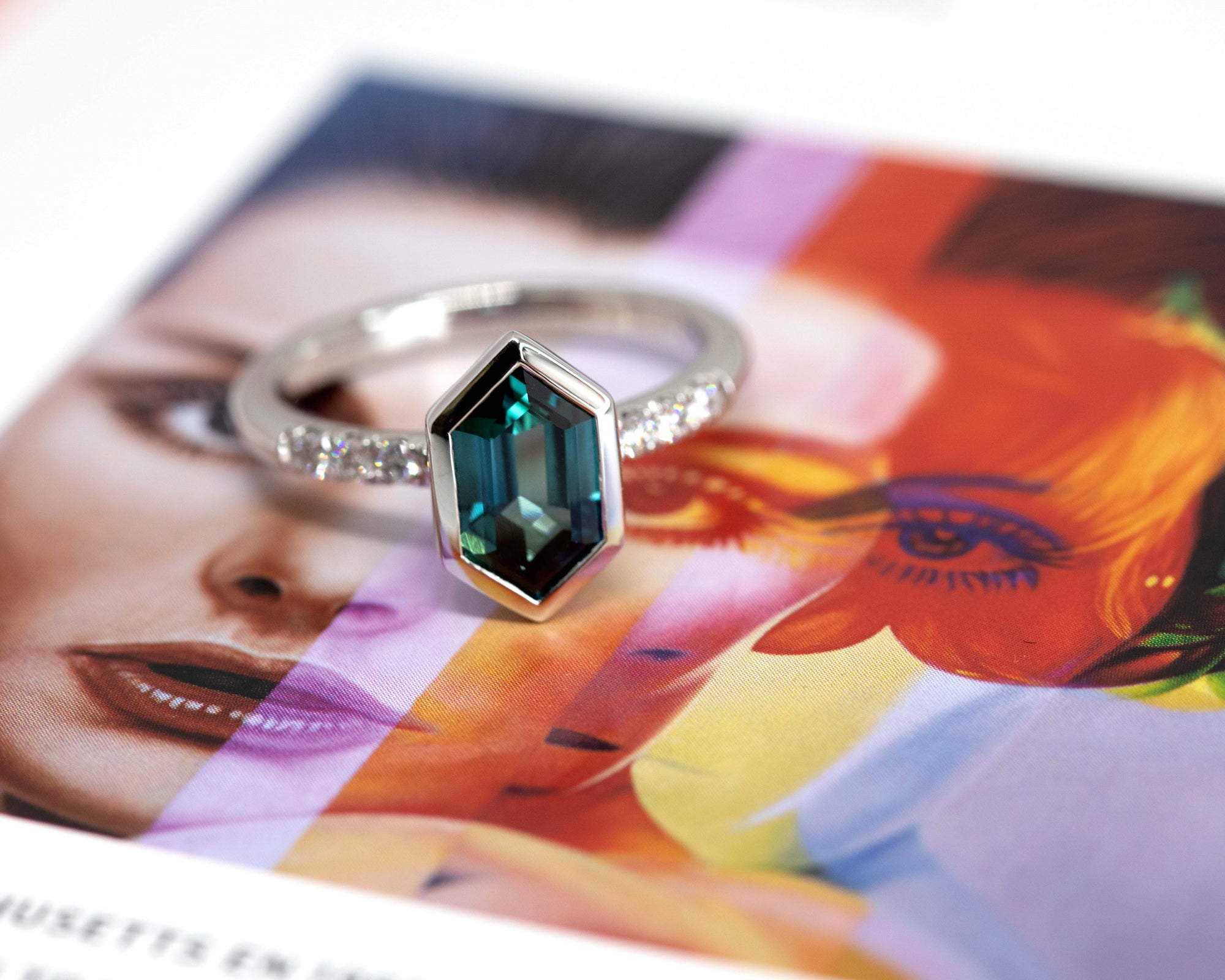 Angled shot of sapphire ring – A contemporary engagement ring featuring an eye-catching blue sapphire and diamond accents, set in a high-polish platinum band.
