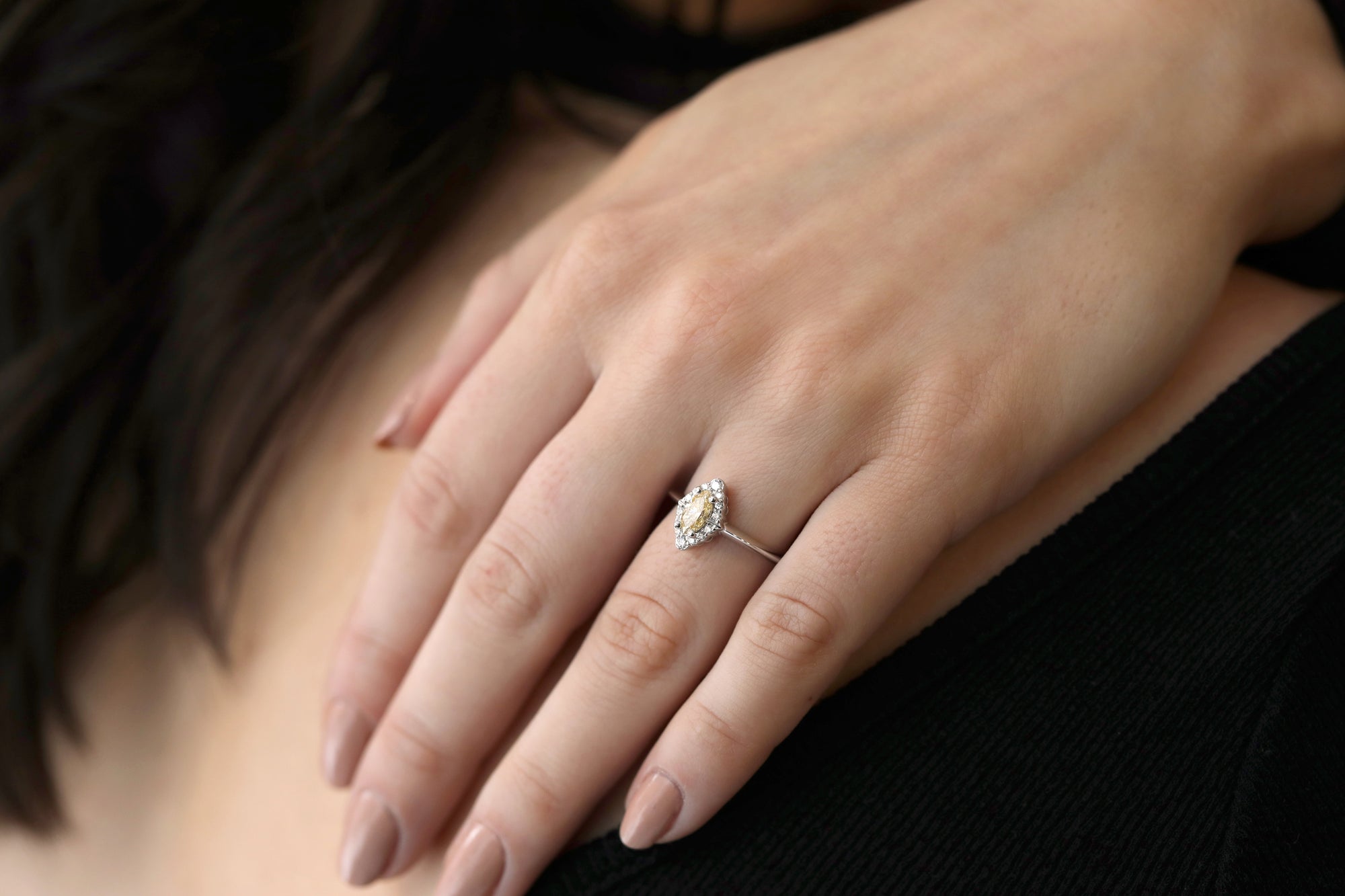 girl with a black shirt wearing a marquise shape yellow diamond bena jewelry custom made engagement ring white gold ring with a yellow color natural gia certified diamond custom made color gems ring little italy montreal fine jewelry designer