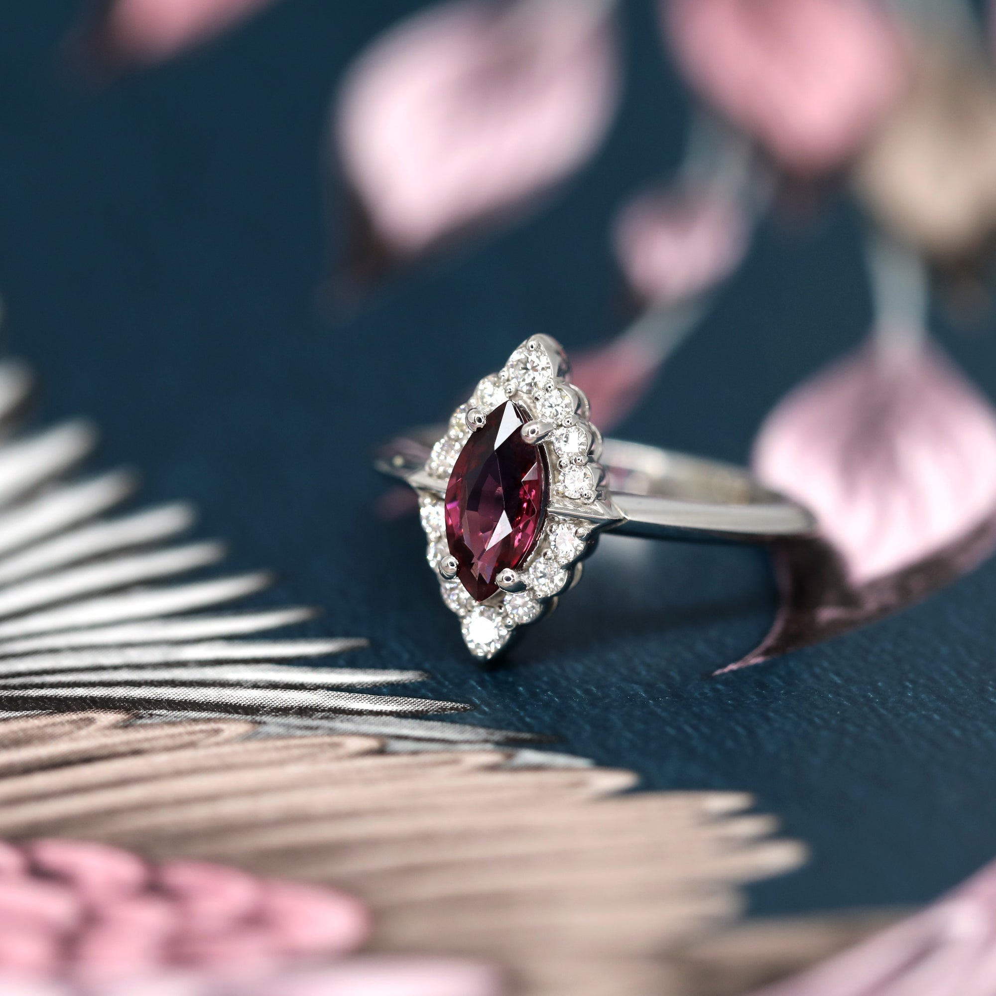 Side view of edgy bridal ring marquise shape red garnet gemstone engagement ring white diamonds small round white gemstone natural maquise garnet red gems custom made in montreal handemade in canada fine jewelry designer