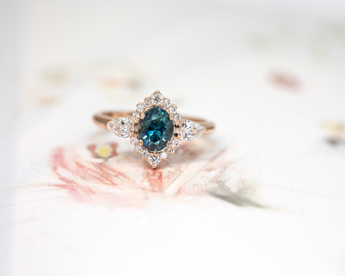 bena jewelry custom made oval shape blue sapphire and diamond custom made ring on a multi color background