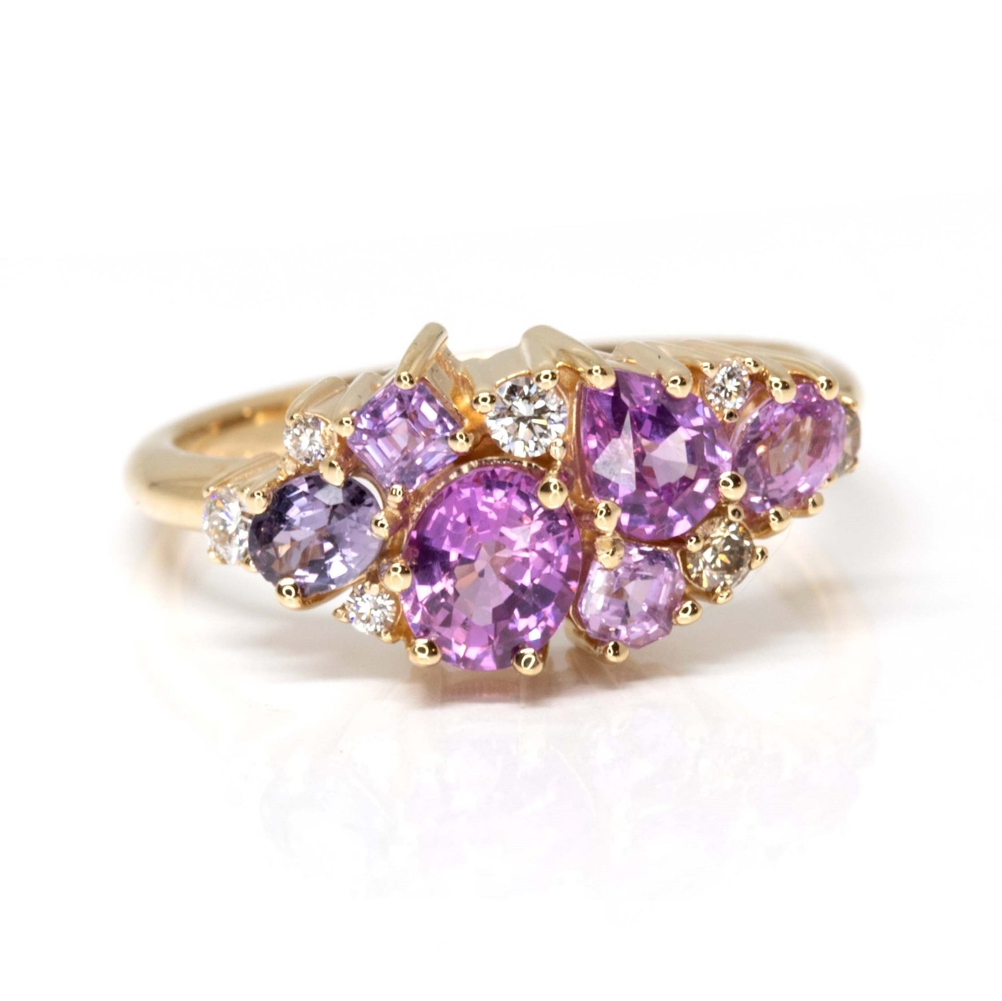 Front view: The Avalanche Pink Sapphire Ring showcasing its artistic arrangement of pink and violet sapphires with diamonds in a polished yellow gold setting. Designed by Bena Jewelry in Montreal, Canada.
