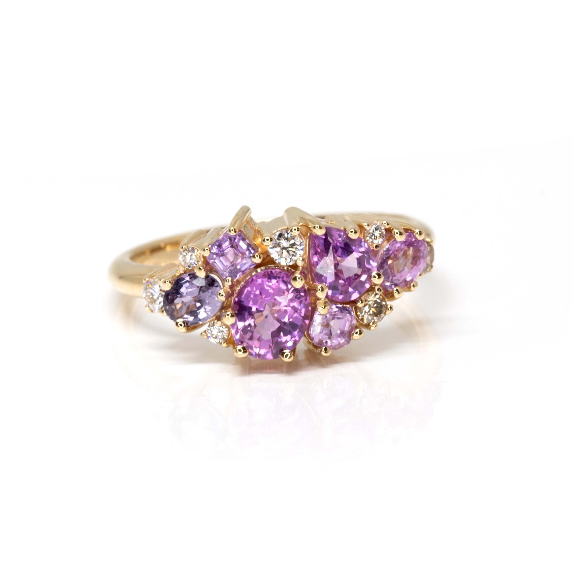 Close-up: Focuses on the vibrant pink and violet hues of the sapphires and the sparkle of the diamonds against the yellow gold. Made by Bena Jewelry, Montreal, Canada.