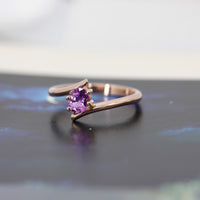 front view of pink sapphire engagament ring cusotm made in montreal by bena jewelry on black and white background