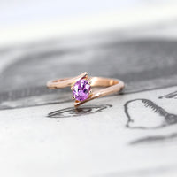 front view of bena jewelry pink sapphire rose gold kink ring edgy engagement ring on balck and white background