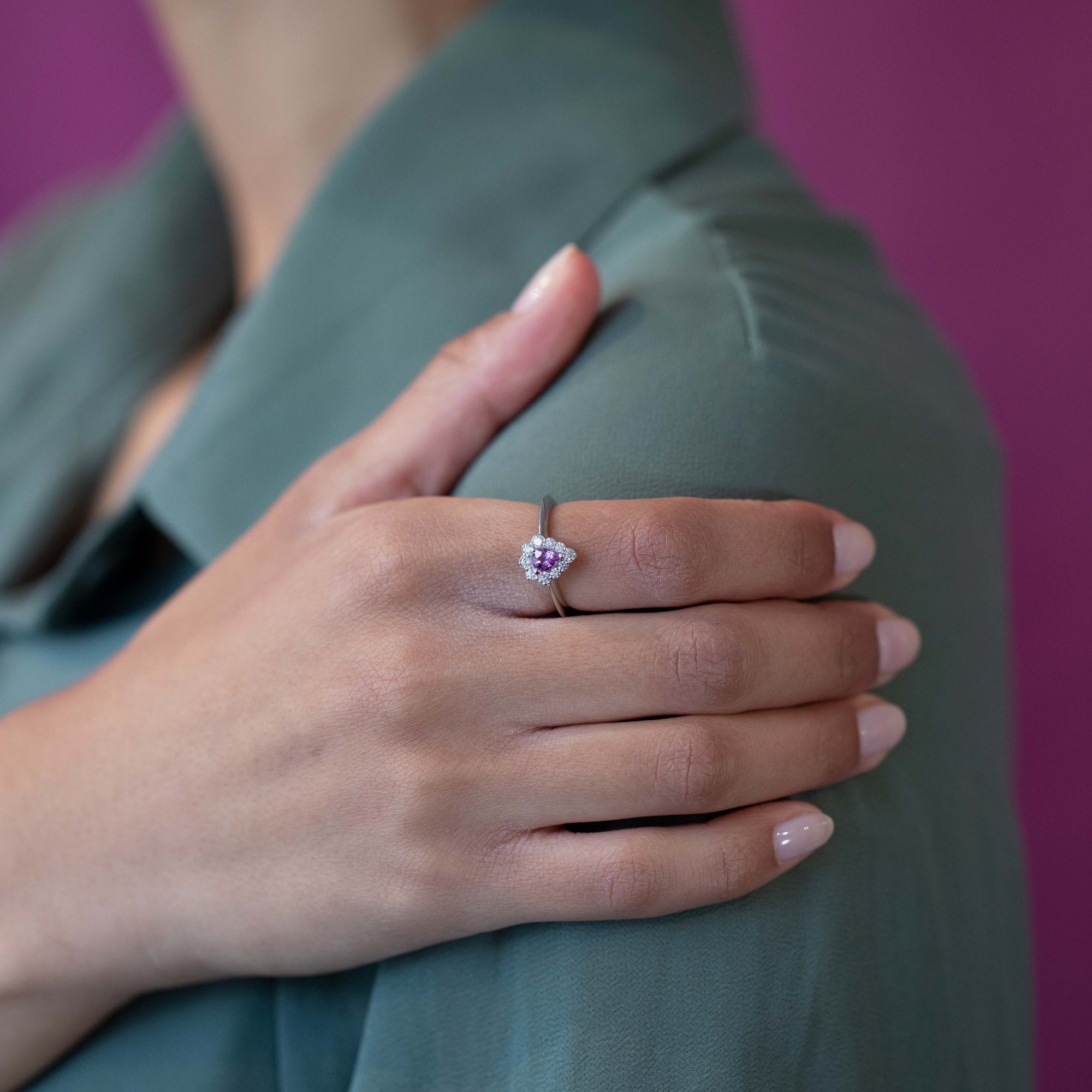 The Aura ring shines on a woman’s hand, emphasizing its graceful pear-cut sapphire and delicate diamond details.