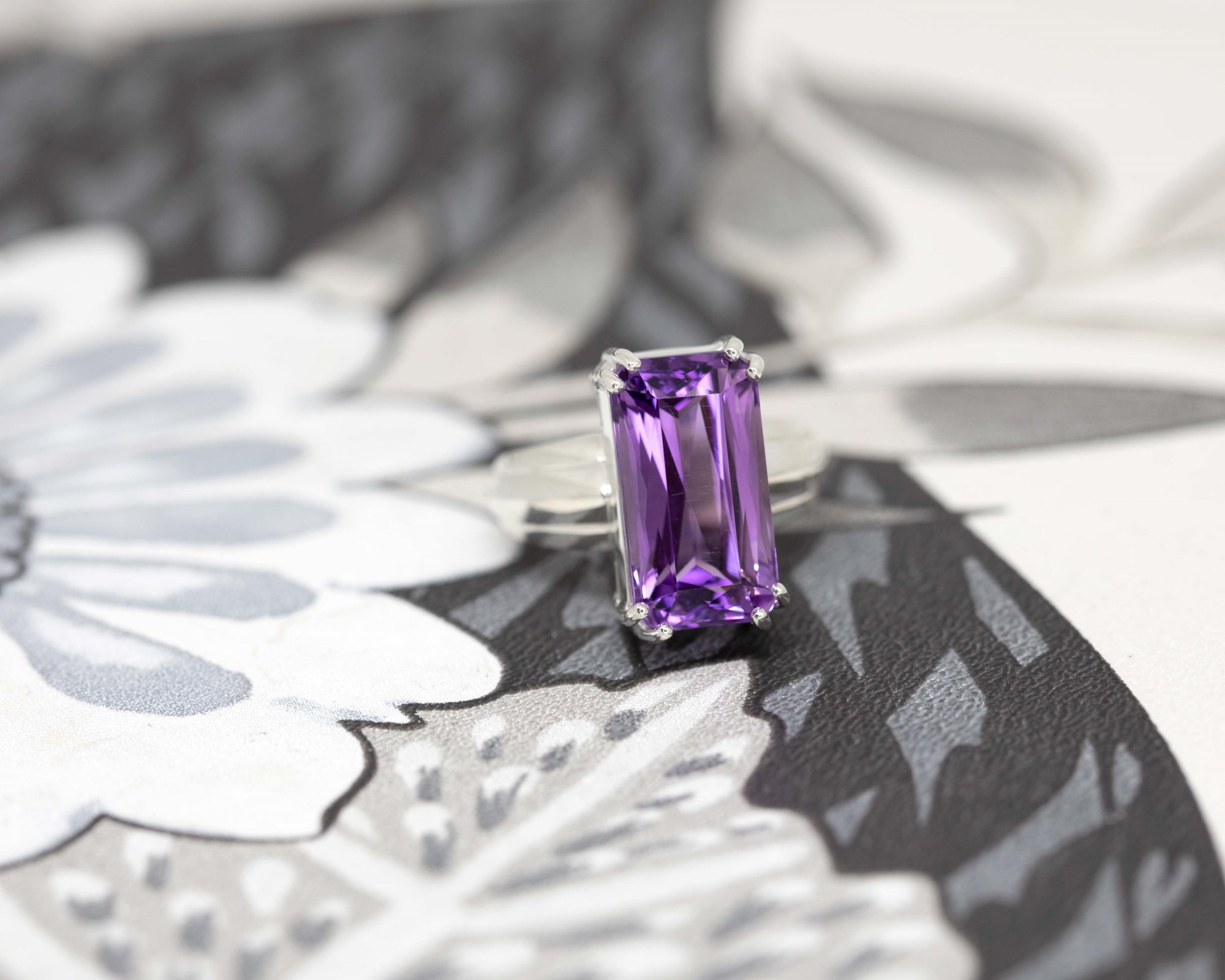 Close-up of amethyst ring on dark background – The deep purple brilliance of the scissor-cut amethyst stands out in this one-of-a-kind statement design by Bena Jewelry.
