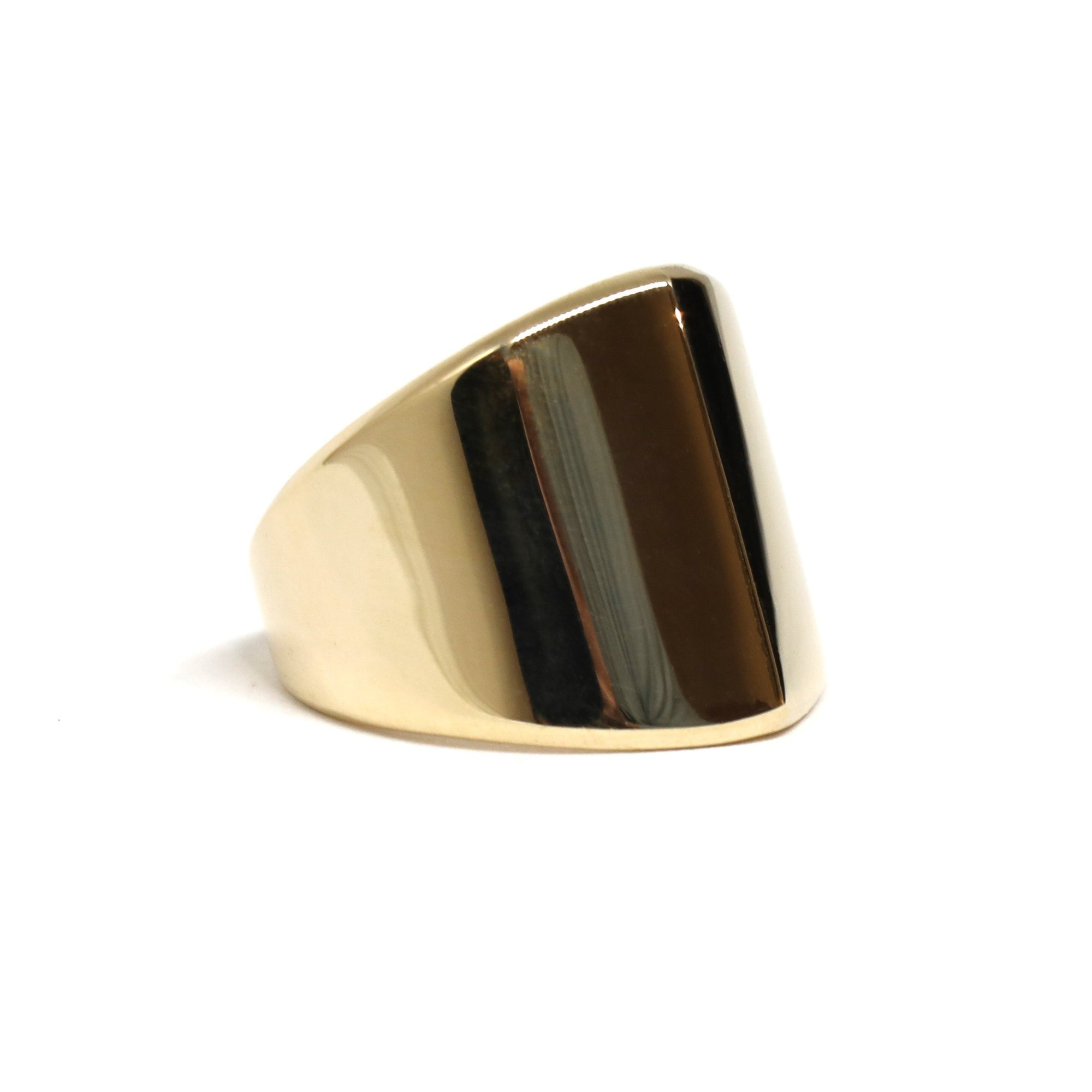 Close-up of boxy gold ring – A sleek and modern geometric ring, featuring a structured, solid gold design with a refined finish.