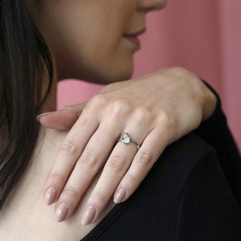 Lifestyle shot of the Toi et Moi ring worn on finger – The warm brown diamond and brilliant white diamond create a striking contrast in this elegant custom-made engagement ring.