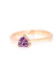 side view of a rose gold ring with a trillion shaped pink purple stone on a white background, this finacailles ring is custom made in montreal