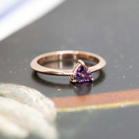 deep purple pink trillion shape rose gold bena jewelry bridal ring on a dark background