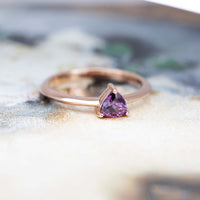 purple garnet rose gold minimalist bridal ring on a multi color background