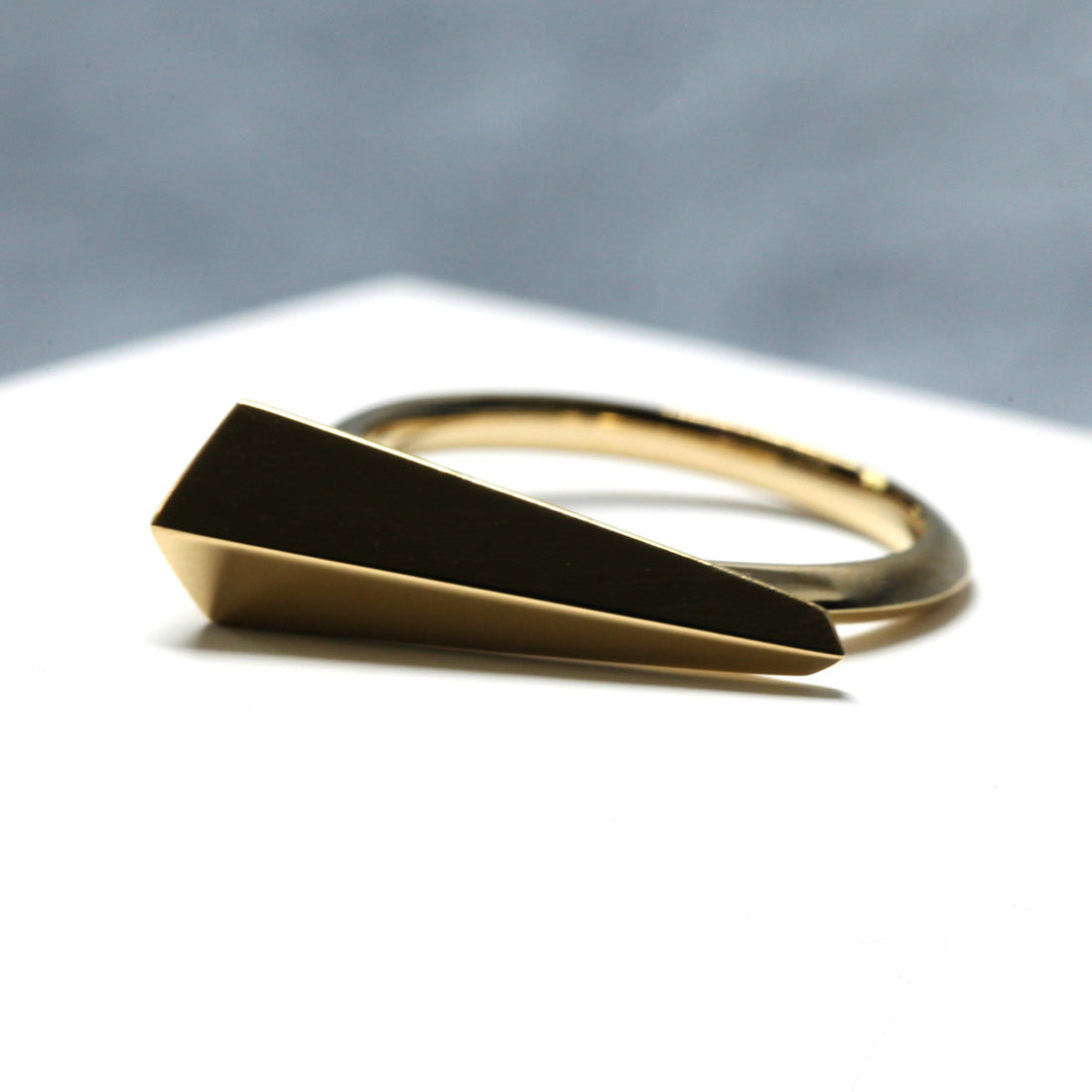 Angled shot of Spine Ring in Yellow Gold – A high-polish statement ring with an architectural edge.