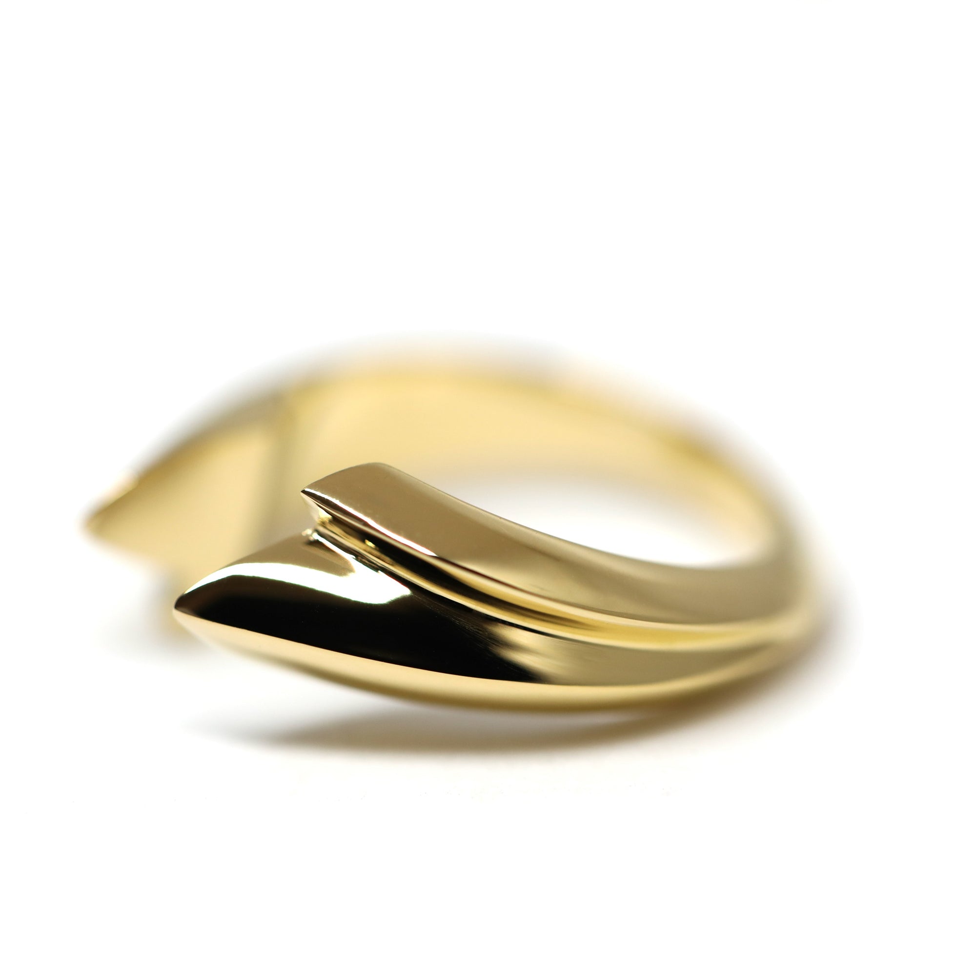Angled shot of Tidal Ring in Yellow Gold – A striking unisex gold ring featuring a smooth, sculptural silhouette.